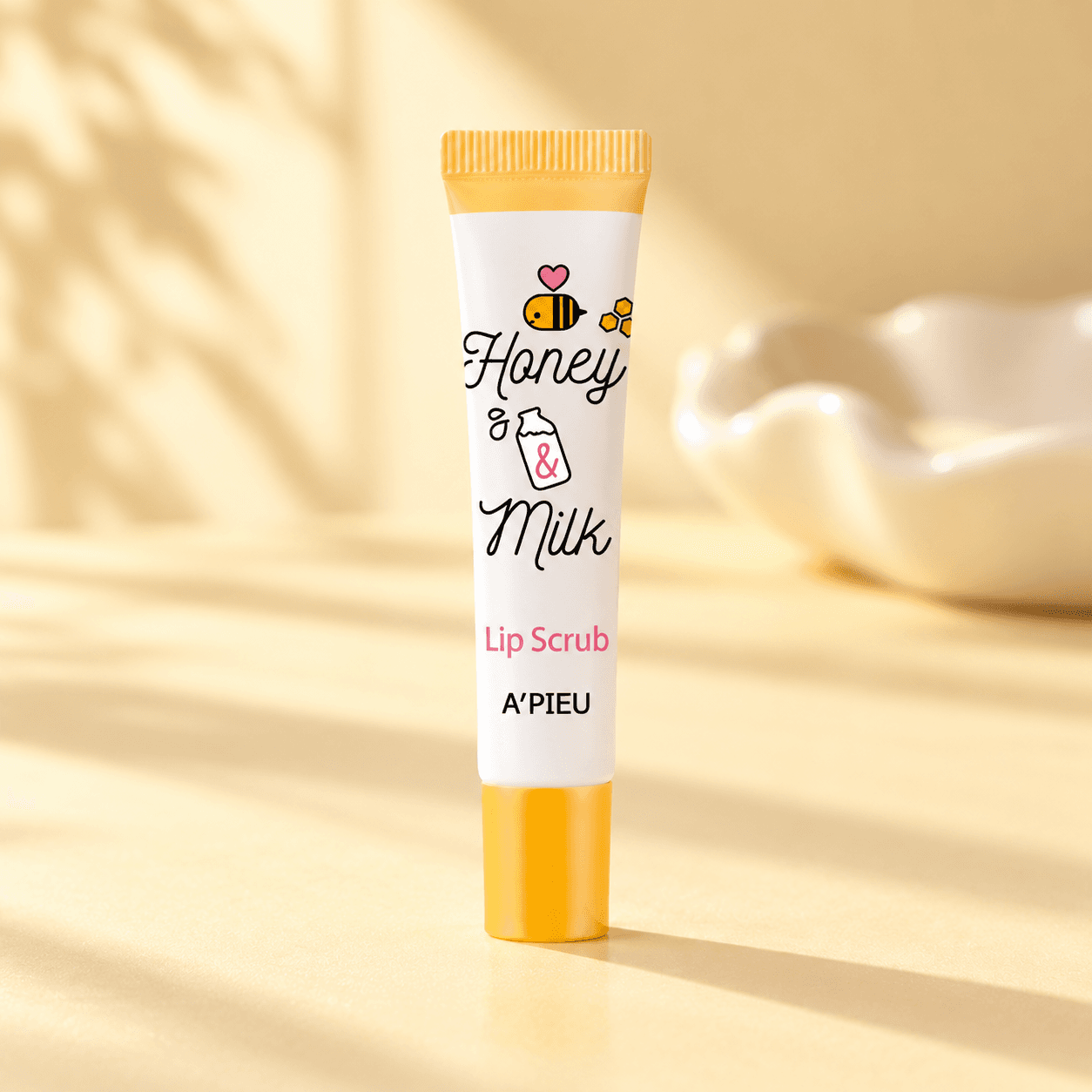 A'pieu Honey & Milk Lip Scrub — Esfoliação Suave 8 ml — composição ilustrativa do produto num ambiente de cuidados de pele
